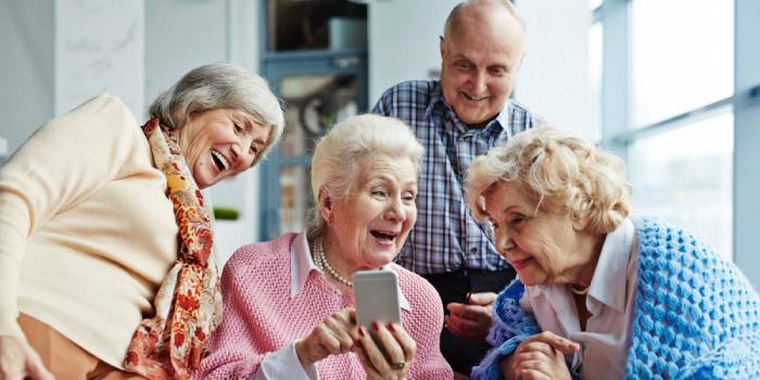 Пожилые люди общаются по Скайпу в телефоне