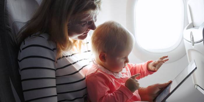 Женщина с ребенком и планшетом в самолете
