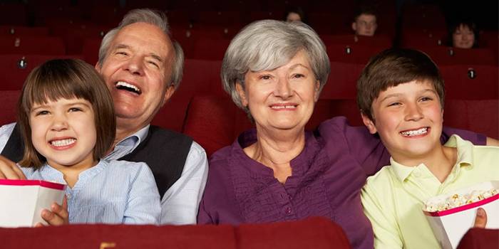 Бабушка с дедушкой и внуки в кинотеатре 