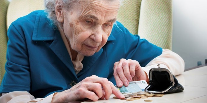 Пожилая женщина считает монеты