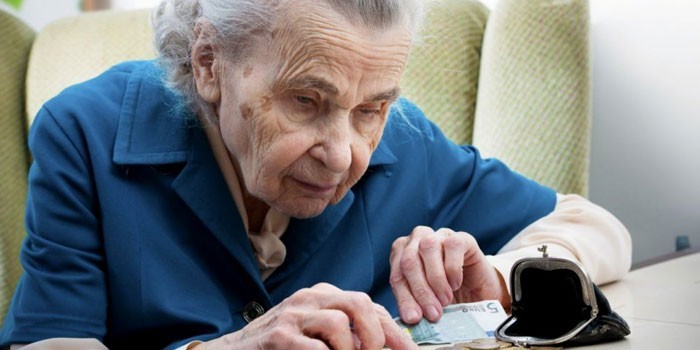 Пожилая женщина считает деньги