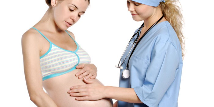 Медик трогает живот беременной девушки