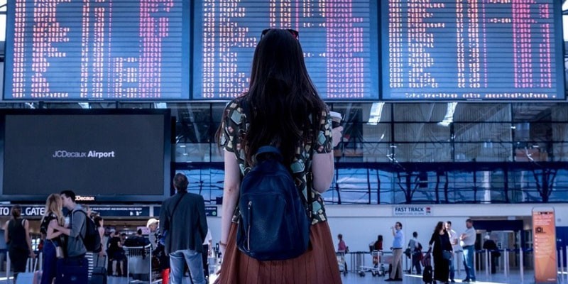 Девушка смотрит на табло в аэропорту