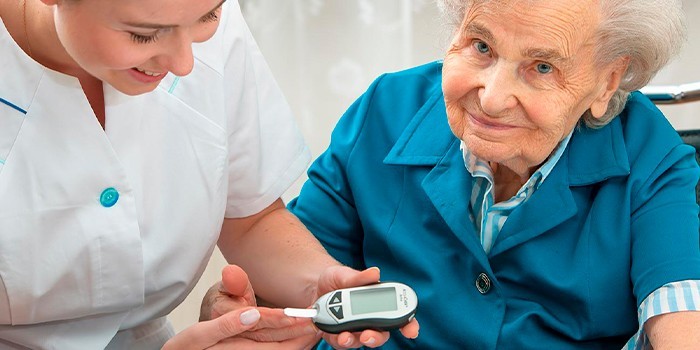 Пожилой женщине измеряют уровень сахара в крови